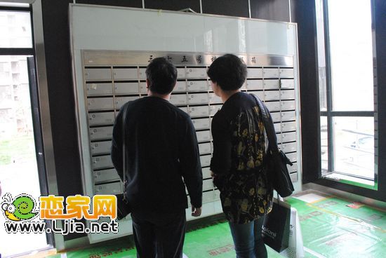 業(yè)主在看門口的信箱設(shè)施