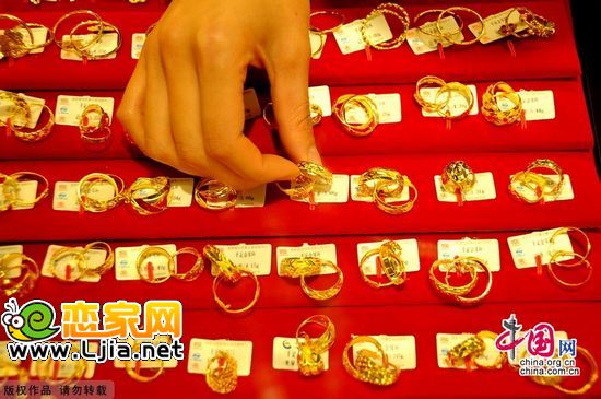 10月26日，在江蘇連云港一家黃金店里，工作人員在展示新款黃金飾品