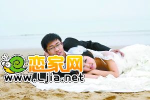 準(zhǔn)新郎尹強(qiáng)和未婚妻在沙灘上拍攝婚紗照 