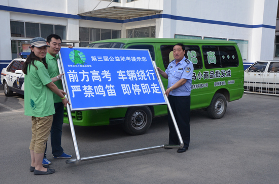 圖為楊順江大隊(duì)長(zhǎng)從江城微公益志愿者手中接過(guò)統(tǒng)一制作的交通禁行提示牌