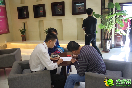 錦繡江南置業(yè)顧問正在幫助購房者簽署協(xié)議