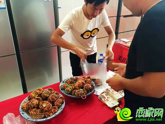 參與活動者領(lǐng)取加工好的螃蟹