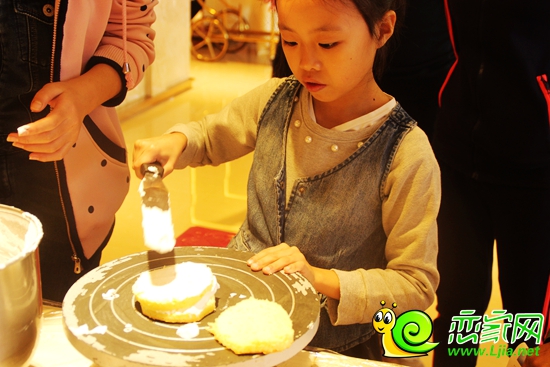 小朋友在羅蘭春天城市展廳內(nèi)進(jìn)行DIY蛋糕的制作