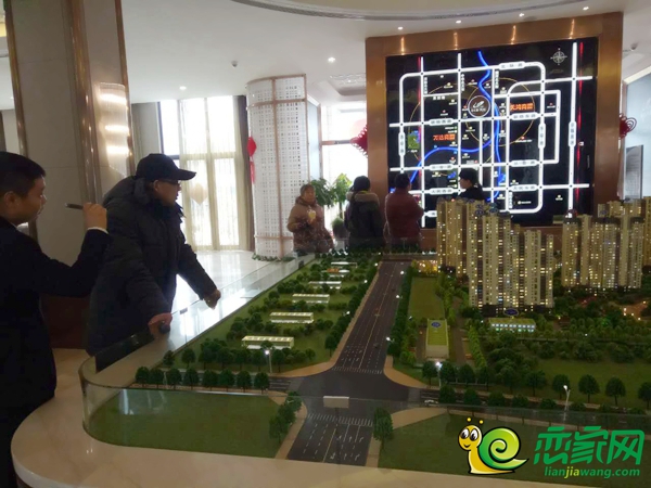 置業(yè)顧問給購房者講解沙盤