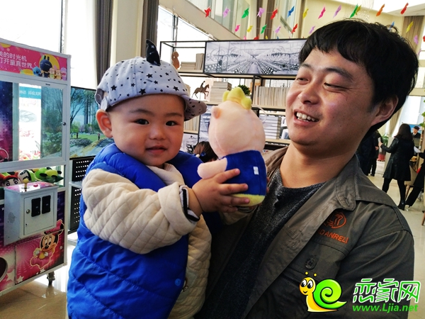 小寶寶的媽媽給他抓了個(gè)娃娃，興奮的合不攏嘴