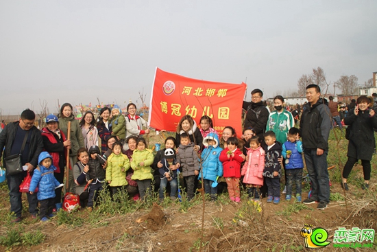 參與植樹的寶寶在種好的小樹面前合影