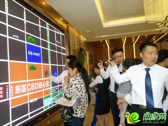 置業(yè)顧問向到訪者講解區(qū)位